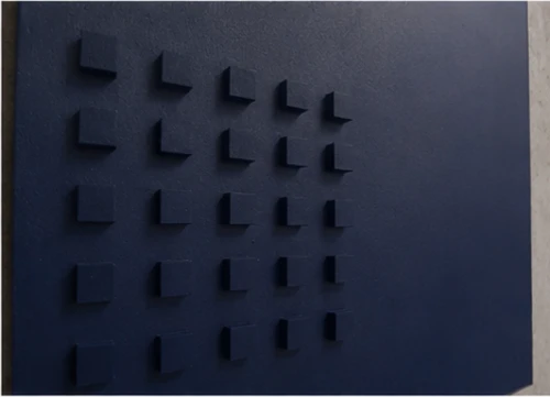 Close view of the panel surface: a grid of small blue blocks in relief, each casting a short shadow