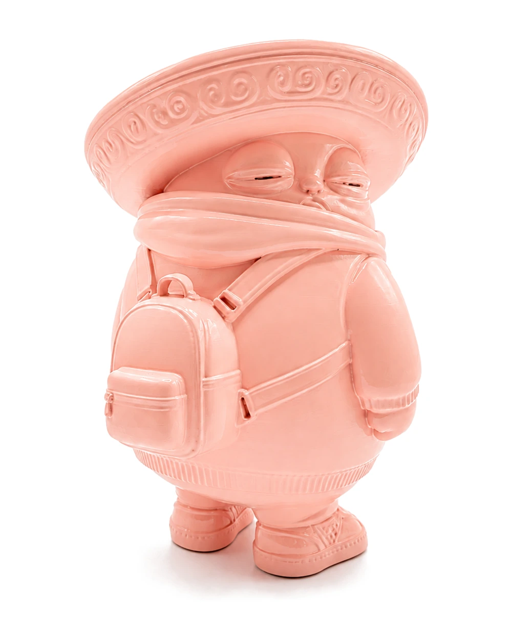 A round pink figure in a wide embroidered sombrero and scarf, two backpacks strapped on, squinting suspiciously at the viewer