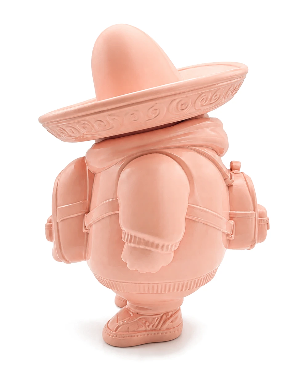 The pink figure from behind, sombrero tipped back, a bedroll and side bags strapped across its round body
